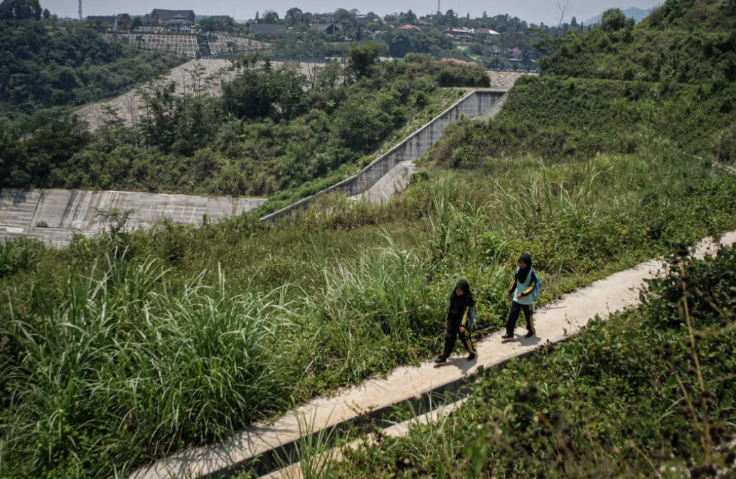 Siswa SD Cibogo terpaksa melewati jalan setapak dipinggir proyek Bendungan Ciawi. (Foto: Rangga Firmansyah/harnas.id)