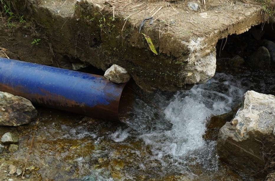 Air jernih mengalir deras dari pipa biru buatan warga di dekat pondasi irigasi yang rusak di Desa Blang Puuk, Kecamatan Beutong Ateuh Banggalang, Kabupaten Nagan Raya, pada Rabu (7/10/2026). Foto: (Mardili/Bithe.co). Salinan ini telah tayang di https://www.bithe.co/news/suara-air-yang-dirindukan-petani-beutong-ateuh/index.html#google_vignette.